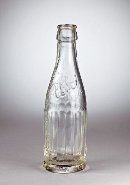 Man sieht eine leere Afri-Cola-Glasflasche.