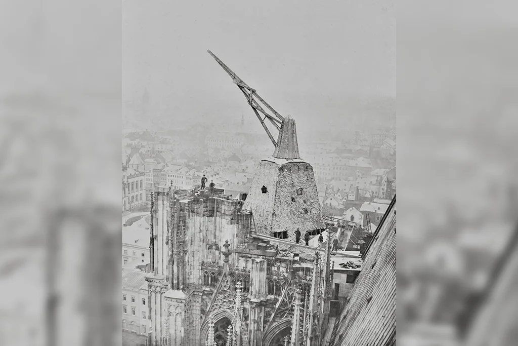 Historische Fotografie des Kölner Doms, auf dem Südturm wird der hölzerne Baukran abgebaut.