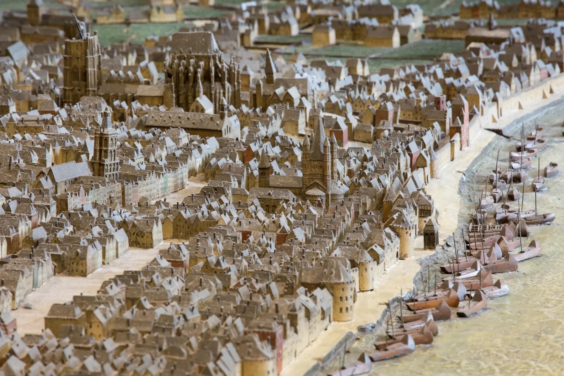 Nahaufnahme des Stadtmodells mit dem Hafen, davor liegen mehrere Modellschiffe am Ufer