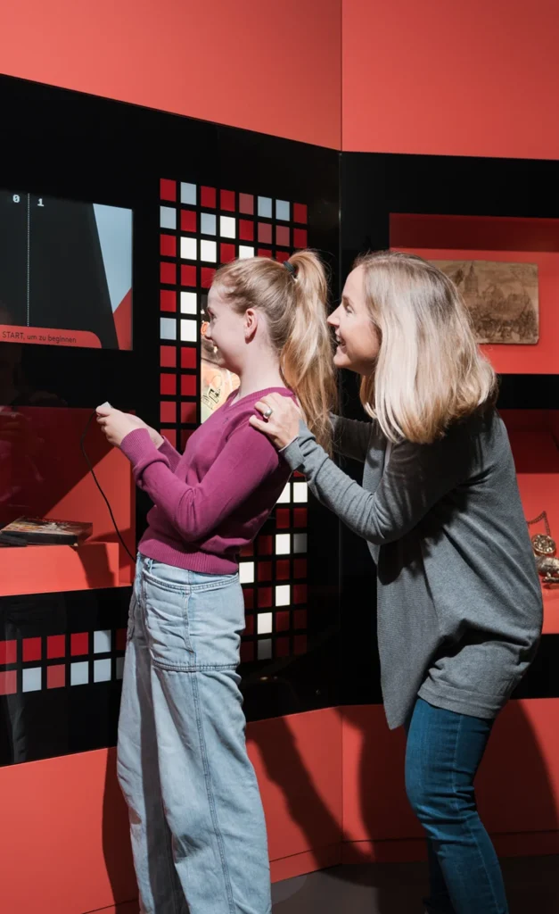 Ein Mädchen schaut mit seiner Mutter auf ein Ausstellungsstück.