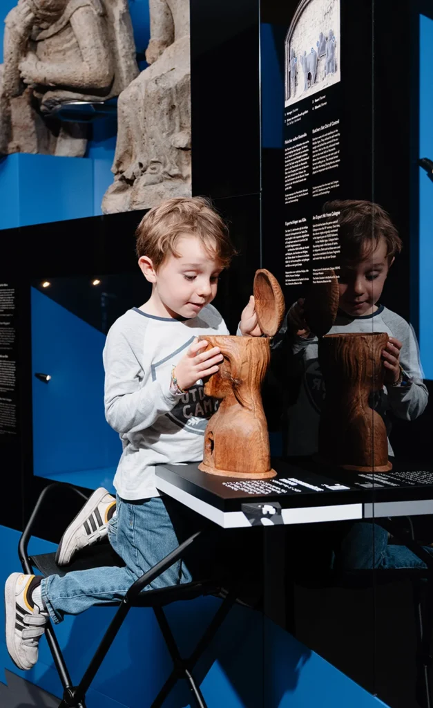 Ein kleiner Junge schaut neugierig in ein Ausstellungsstück.